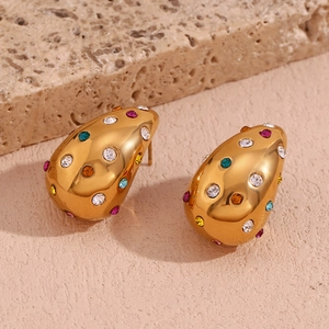 Boucles d'oreilles gouttes dorées avec pierres de zircon colorées sur support pierre