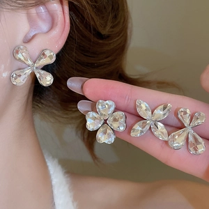 Detailed view of irregular heart-shaped crystal earrings with polished silver metal base