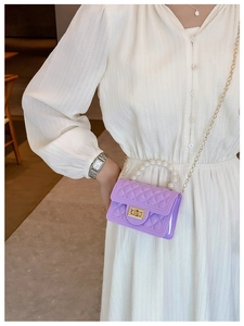 Detail view of purple jelly bag with pearl handle and diamond lattice texture