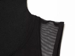 Close-up detail of black double-layered dress showing fine mesh and knitted fabric texture