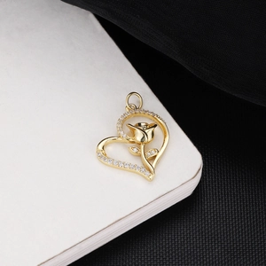 Detailed view of 18K gold plated heart pendant with rose and zircon on white book