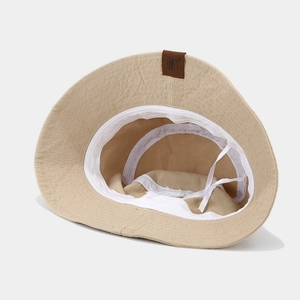 Cappello a secchiello in cotone beige con toppa in pelle e coulisse regolabile