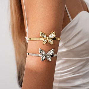 Detailed view of butterfly arm cuff with sparkling rhinestones on model's arm