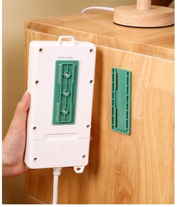 Detail of green sliding rail socket fixer being mounted on a wooden cabinet surface