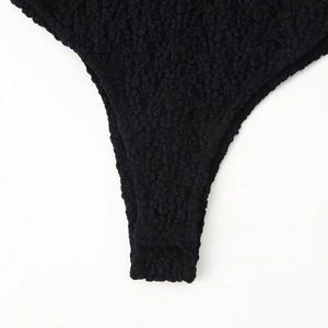 Women's black bubble textured bodysuit with elegant lace and bow details in a sleek fit