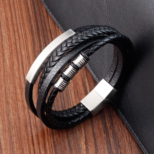 Detail of multi-layer black braided leather bracelet with silver magnetic buckle