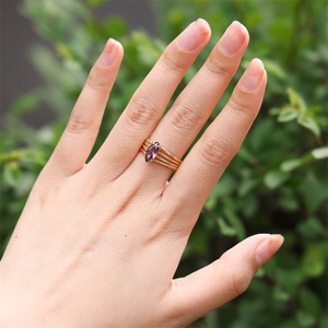 Detail of a four-layer gold beaded ring featuring a marquise-cut purple zircon stone