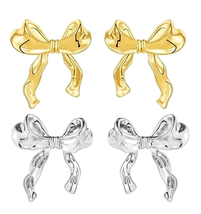 Polished gold and silver ribbon bow earrings showing intricate 3D fold details