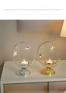 Detail of moon-shaped metal candle holders with hollow carvings and hanging star ornaments