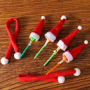 Close-up of mini Santa hats and scarves decorating lollipops on a wooden table