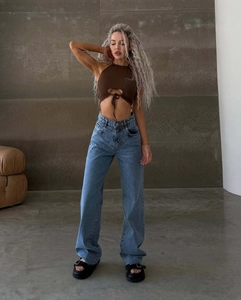 Detail einer High-Waist-Jeans mit weitem Bein und Neckholder-Top in Blau