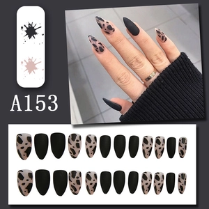 Detail of 24pcs matte black stiletto press-on nails with cow print pattern and texture