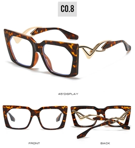 Detail view of tortoiseshell cat-eye sunglasses with curved gold metal hollow temples