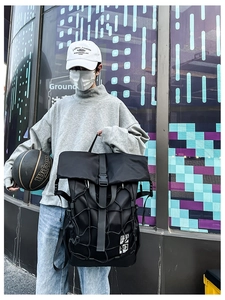 Detail of a black functional sports backpack featuring an elastic mesh net for basketball