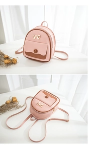Detail of pink mini backpack featuring golden bow decor and brown front pocket flap