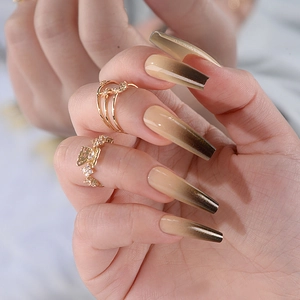 Close-up of long coffin nails with nude to black gradient and subtle shimmer finish