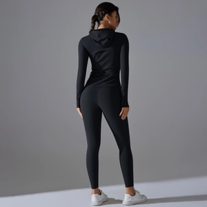 Dettaglio della giacca da yoga con cappuccio e leggings in tessuto nero opaco e vestibilità slim