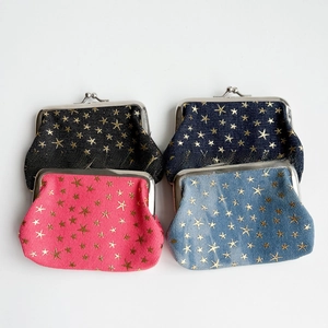 Detail of four denim coin purses with gold star patterns and vintage metal kiss-lock closure