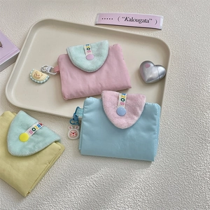 Detail of sweet fabric coin purse with cartoon charms and plush patchwork in pastel colors