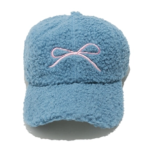 Detailed close-up of blue lamb wool baseball cap featuring pink bow embroidery