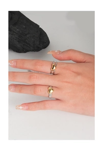 Detail view of heart-shaped two-tone rings with textured silver bands and gold heart accents