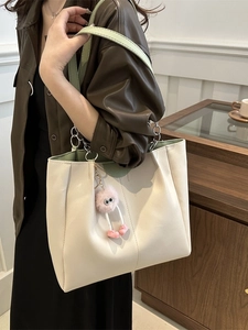 Grande borsa tote a contrasto beige e verde in pelle PU indossata da una modella