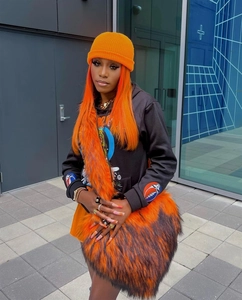 Detail of vibrant orange and black faux fur crossbody heart bag with street style knit hat
