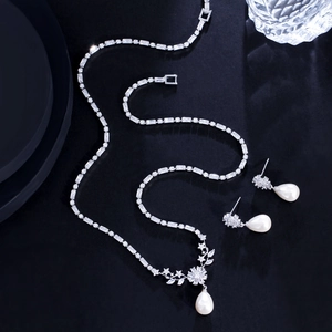 Detailed view of silver jewelry set with zircon accents and white teardrop pearls