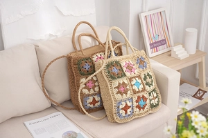Close-up of handmade crochet granny square tote bags in brown and beige on a sofa