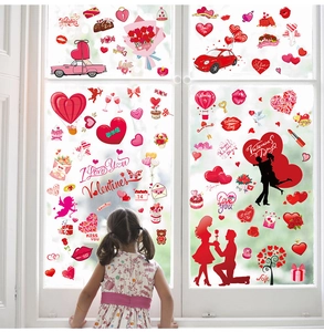 Close-up of heart window stickers on glass with a child in a home setting