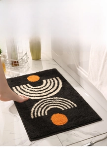 Detail of geometric non-slip bathroom mat with soft texture and artistic orange patterns