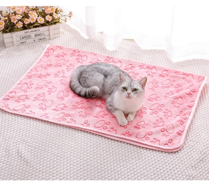 Pink flannel pet blanket with cat paw prints, cozy for cats and dogs in home setting