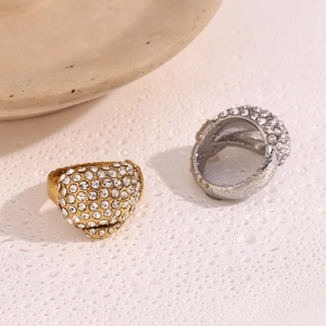 Macro view of gold and silver luxury rings with full pave zircon stones on a wet surface