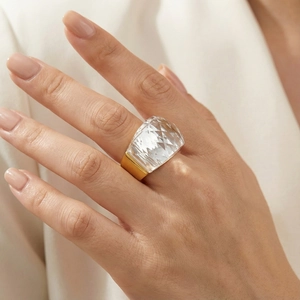 Detail showing an 18K gold plated wide band ring with a large faceted crystal on hand