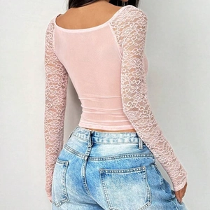 Rückansicht eines rosa Spitzen-Langarm-Crop-Tops kombiniert mit hellblauen Vintage-Jeans