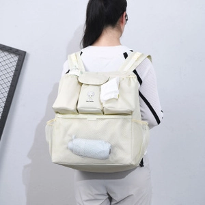 Detail of cream multi-pocket backpack with cartoon print and mesh storage compartments