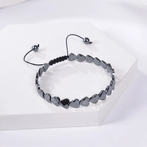 Macro shot of adjustable braided bracelet with heart-shaped black hematite magnetic beads