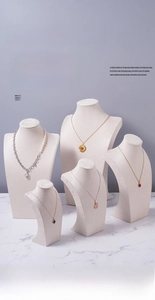 Detail view of five minimalist velvet mannequin necklace display stands in light grey tone