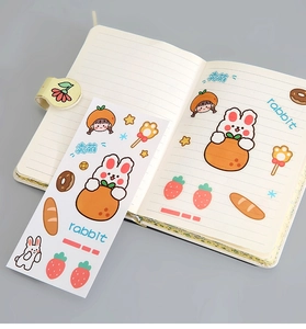 Detail of cute rabbit and strawberry PVC stickers on a notebook for DIY decoration