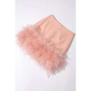 Vue détaillée de la mini-jupe rose avec un ourlet luxueux en plumes d'autruche et tissu