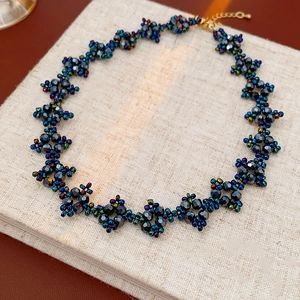 Detail of handcrafted beaded choker necklace featuring blue and purple floral patterns
