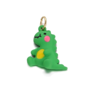 Detailed close-up of a cute green dinosaur pendant charm with a gold metal ring accessory