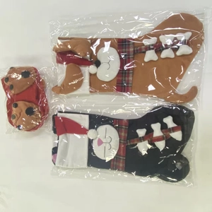 Detail of cartoon dog Christmas stockings and matching pet shoes in retail packaging