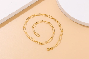 Close-up of golden stainless steel textured oval link chain necklace with lobster clasp
