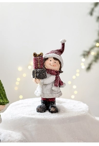 Detail of Christmas girl figurine in plush coat and red scarf holding gift boxes with snow texture