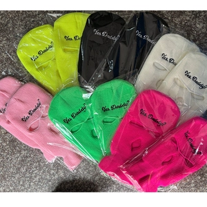 Bulk packaging of knitted three-hole ski masks with "Yes Daddy?" embroidery in various colors