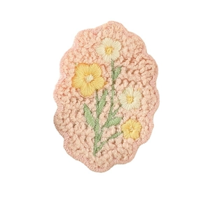 Delicate pink flower embroidery patch with yellow petals and green leaves for DIY crafts