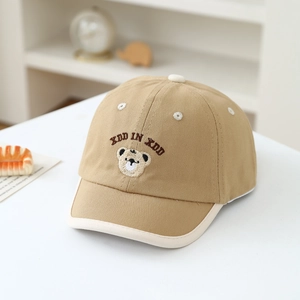 Close-up of cute bear embroidery and cream piping on a khaki cotton baseball cap