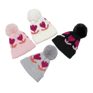 Winter knitted baby hats with flower patterns and large pom-poms in four colors