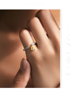 Detail of S925 silver ring featuring a yellow pear-shaped diamond and pavé crystals